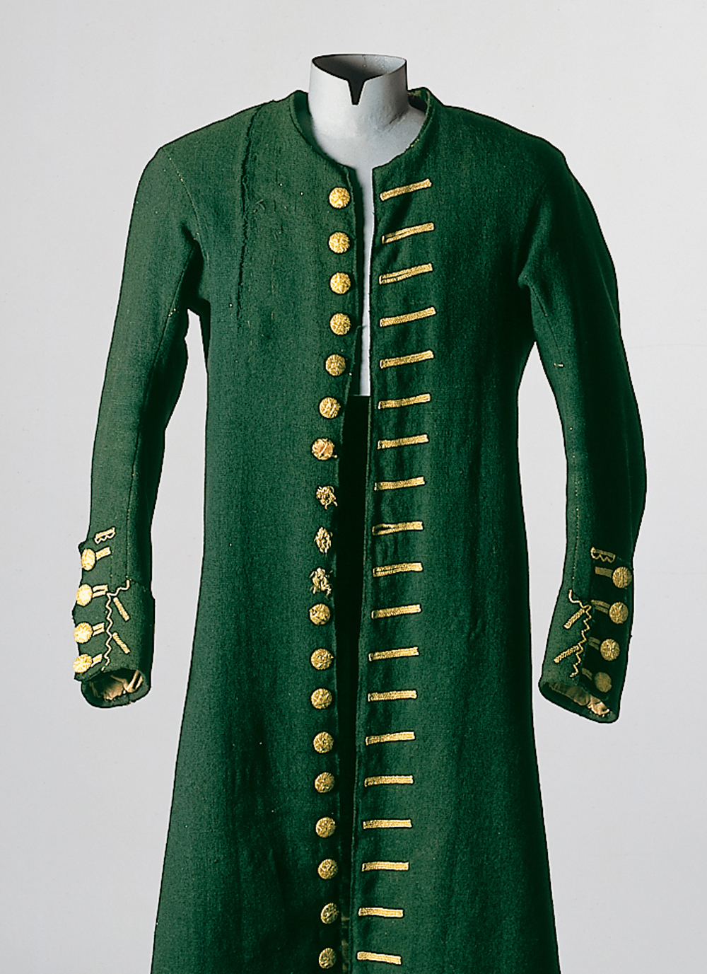 Eine Kleiderpuppe präsentiert einen sogenannten "Justaucorps" (Rock) in der Farbe waldgrün mit goldenen Knöpfen und verzierten Knopflöchern. Das Kleidungsstück für Herren stammt aus Lenggries, und ist datiert um 1810.